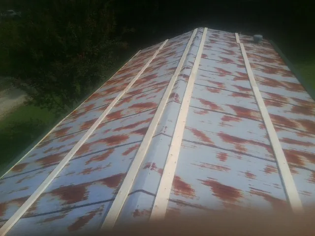 Rusted metal roof panels with new wood purlins before replacement — Storm Damage Roof Repair in Newtonville by Roofing Brothers